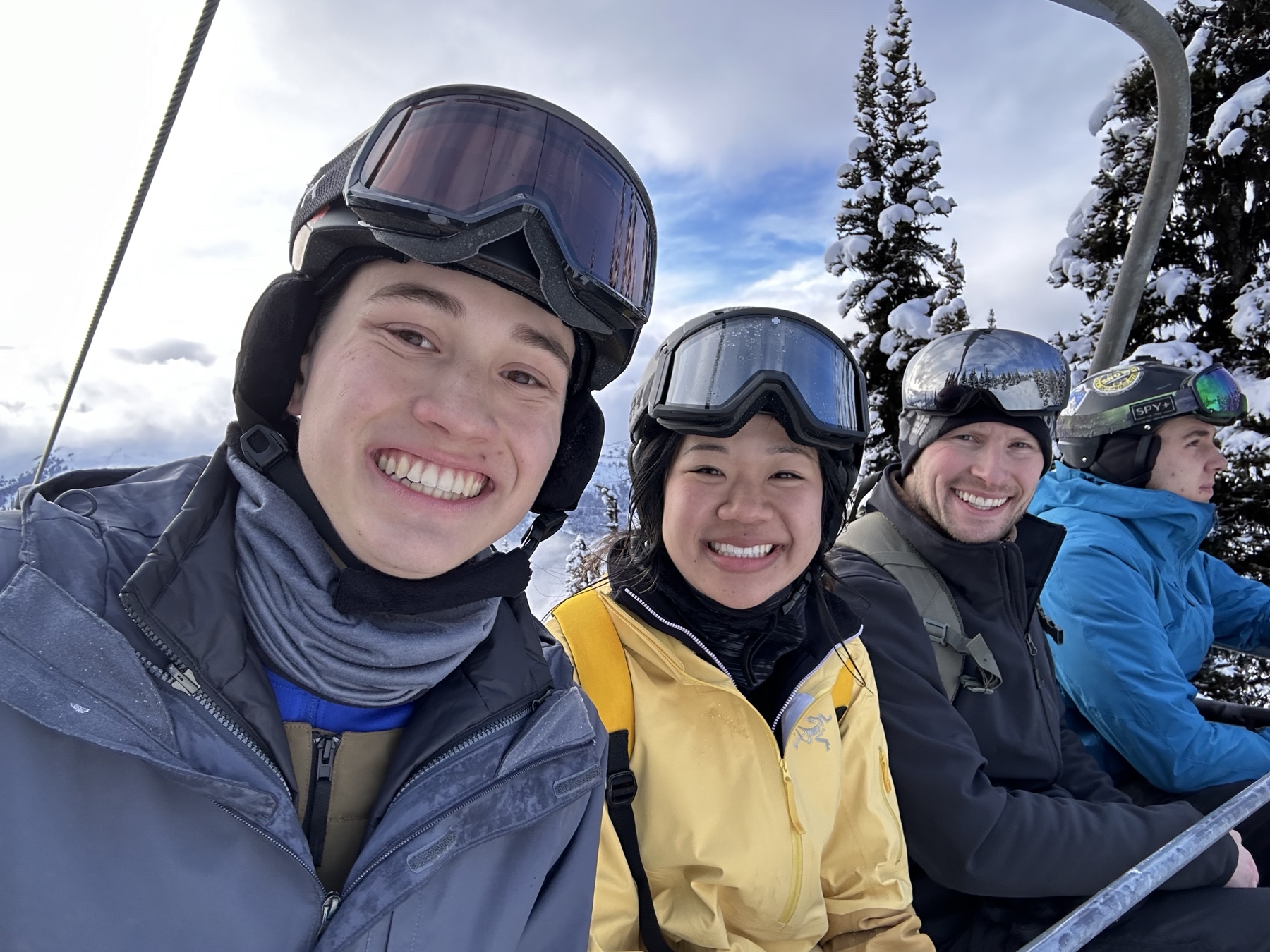 Tiffany, Josiah, and friends smiling together on a snowy chairlift